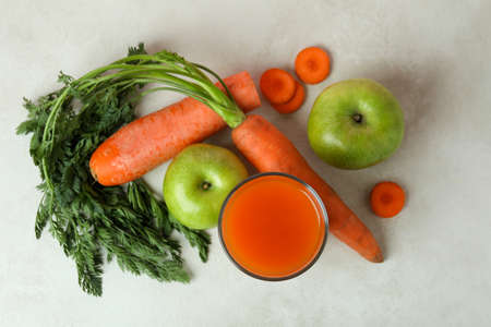 Glass of juice and ingredients on white textured backgroundの写真素材