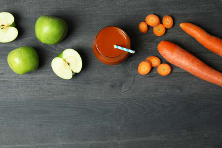 Glass of juice and ingredients on dark wooden backgroundの写真素材