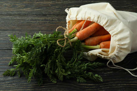 Bag with fresh carrot on wooden backgroundの写真素材
