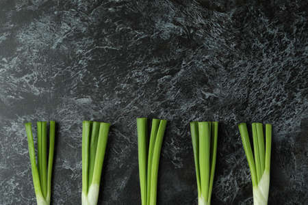 Fresh green onion on black smokey background