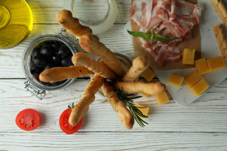 Grissini sticks and snacks on white wooden backgroundの写真素材