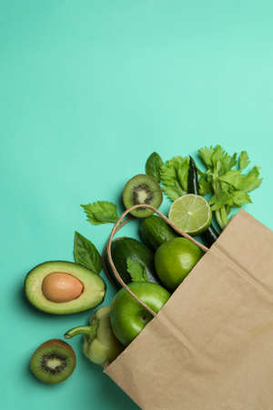 Paper bag with green vegetables on mint backgroundの写真素材