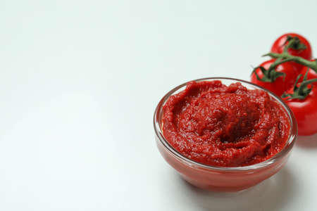 Bowl of tomato paste and tomatoes on white backgroundの写真素材