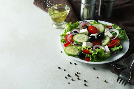 Concept of delicious food with Greek salad on white textured backgroundの写真素材