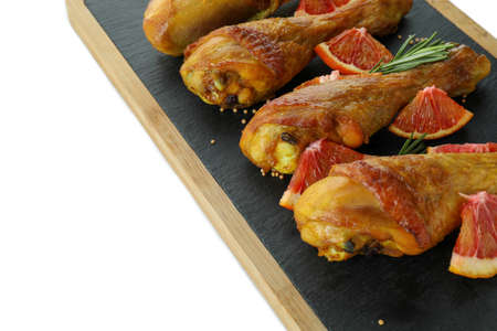 Board with roast chicken drumsticks isolated on white backgroundの写真素材
