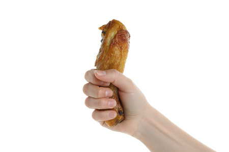 Female hand hold roast chicken drumstick, isolated on white backgroundの写真素材