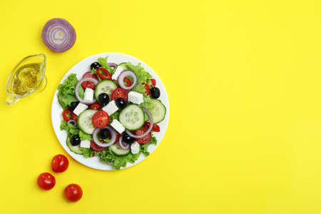 Concept of delicious food with Greek salad on yellow backgroundの写真素材