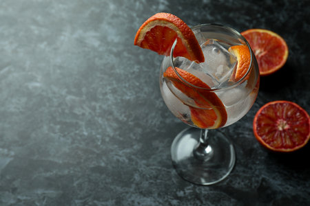 Glass of cocktail with grapefruit on black smokey tableの写真素材