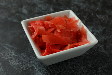 Bowl with red pickled ginger on black smokey backgroundの写真素材