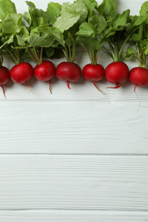 Fresh radish on white wooden background, space for text