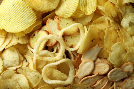 Different snacks on whole background, close up