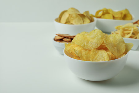 Bowls with different snacks on white backgroundの写真素材