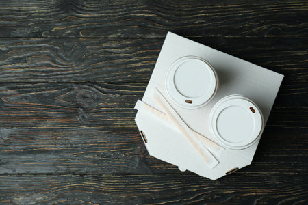Pizza box and paper cups on wooden background