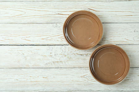 Empty paper bowls on white wooden tableの写真素材