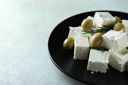 Plate with feta cheese, olives and rosemary on white textured backgroundの写真素材