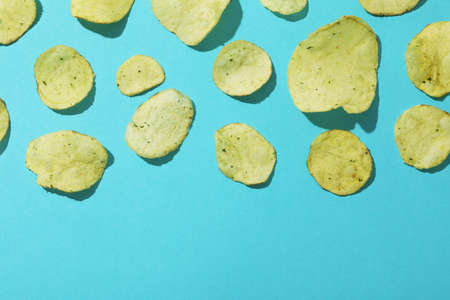 Potato chips on blue background, space for textの写真素材
