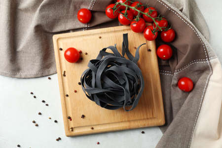 Cutting board with black uncooked pasta, top viewの写真素材