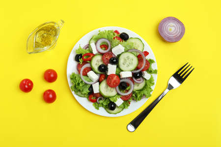 Concept of delicious food with Greek salad on yellow backgroundの写真素材