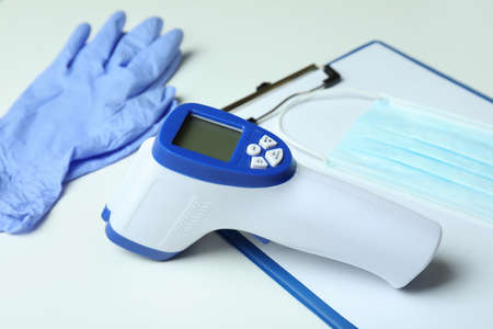 Medical tools and thermometer gun on white background