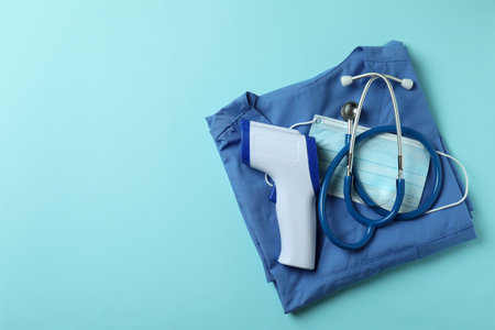 Medical tools and thermometer gun on blue backgroundの写真素材