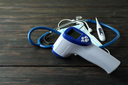 Medical concept with thermometer gun on wooden background