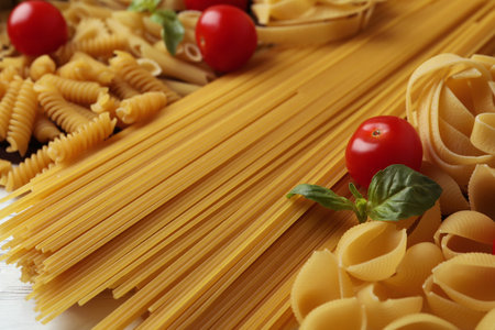 Uncooked pasta, tomatoes and basil, close upの写真素材