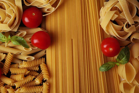 Uncooked pasta, tomatoes and basil, close upの写真素材