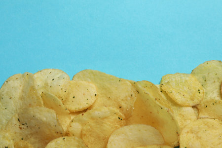 Potato chips on blue background, space for textの写真素材