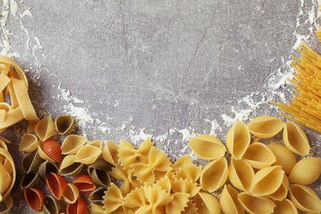 Uncooked pasta and flour on gray textured backgroundの写真素材