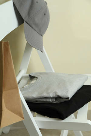 Wooden chair with black and gray sweatshirts