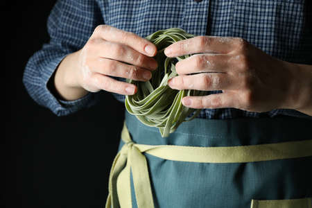 Woman hold uncooked green pasta, close upの写真素材