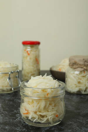 Glass jars of sauerkraut on black smokey tableの写真素材