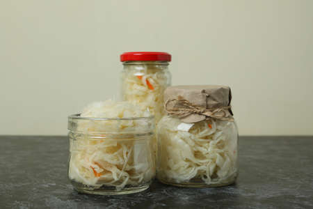 Glass jars of sauerkraut on black smokey tableの写真素材