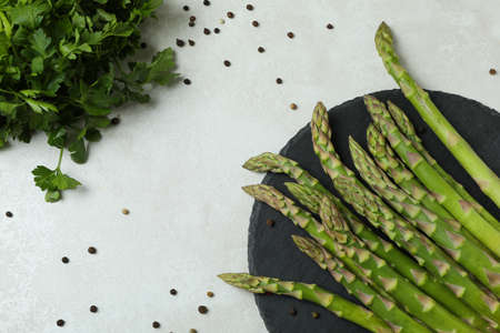 Asparagus, parsley and pepper on white textured tableの写真素材