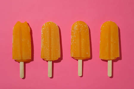 Mango or caramel ice cream sticks on pink background