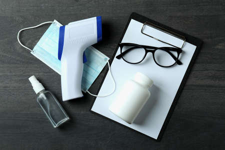 Medical tools and thermometer gun on dark wooden backgroundの写真素材