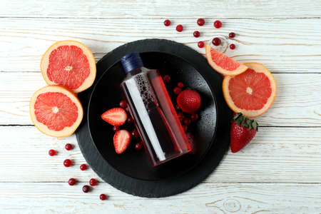 Natural shower gel and ingredients on white wooden background