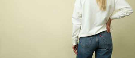Young woman in white sweatshirt against beige background