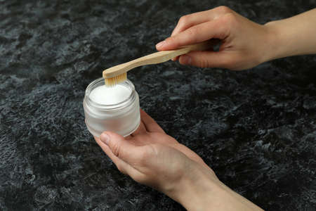 Female hand hold tooth powder and toothbrush on black smokey backgroundの写真素材