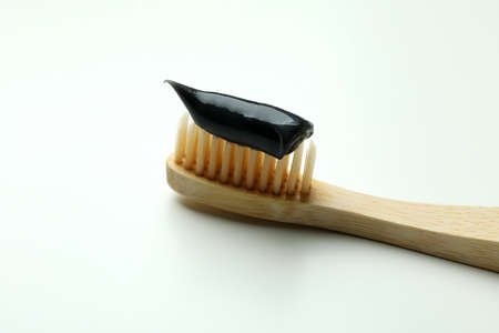 Eco friendly toothbrush with black toothpaste on white background