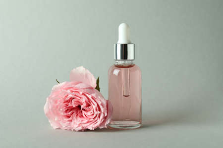 Bottle with rose essential oil and rose on light gray backgroundの写真素材