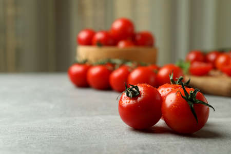 Fresh cherry tomato on gray textured table, close upの写真素材