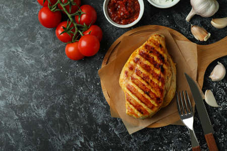 Concept of tasty eating with grilled chicken on black smokey backgroundの写真素材