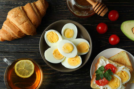 Concept of tasty breakfast with boiled eggs on wooden table