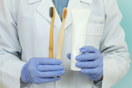 Doctor hold toothpaste and toothbrushes on blue backgroundの写真素材