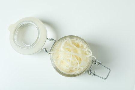 Glass jar of sauerkraut on white background