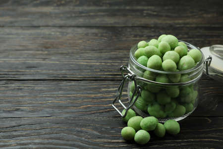 Glass jar with wasabi nuts on rustic wooden backgroundの写真素材