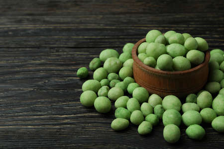 Bowl of wasabi nuts on rustic wooden backgroundの写真素材