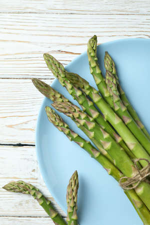 Plate with green asparagus on wooden backgroundの写真素材