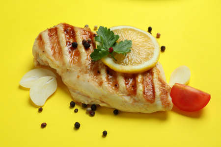 Grilled chicken meat and ingredients on yellow background